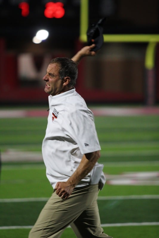 High school football coach on the sideline — game day sports photography by Striide